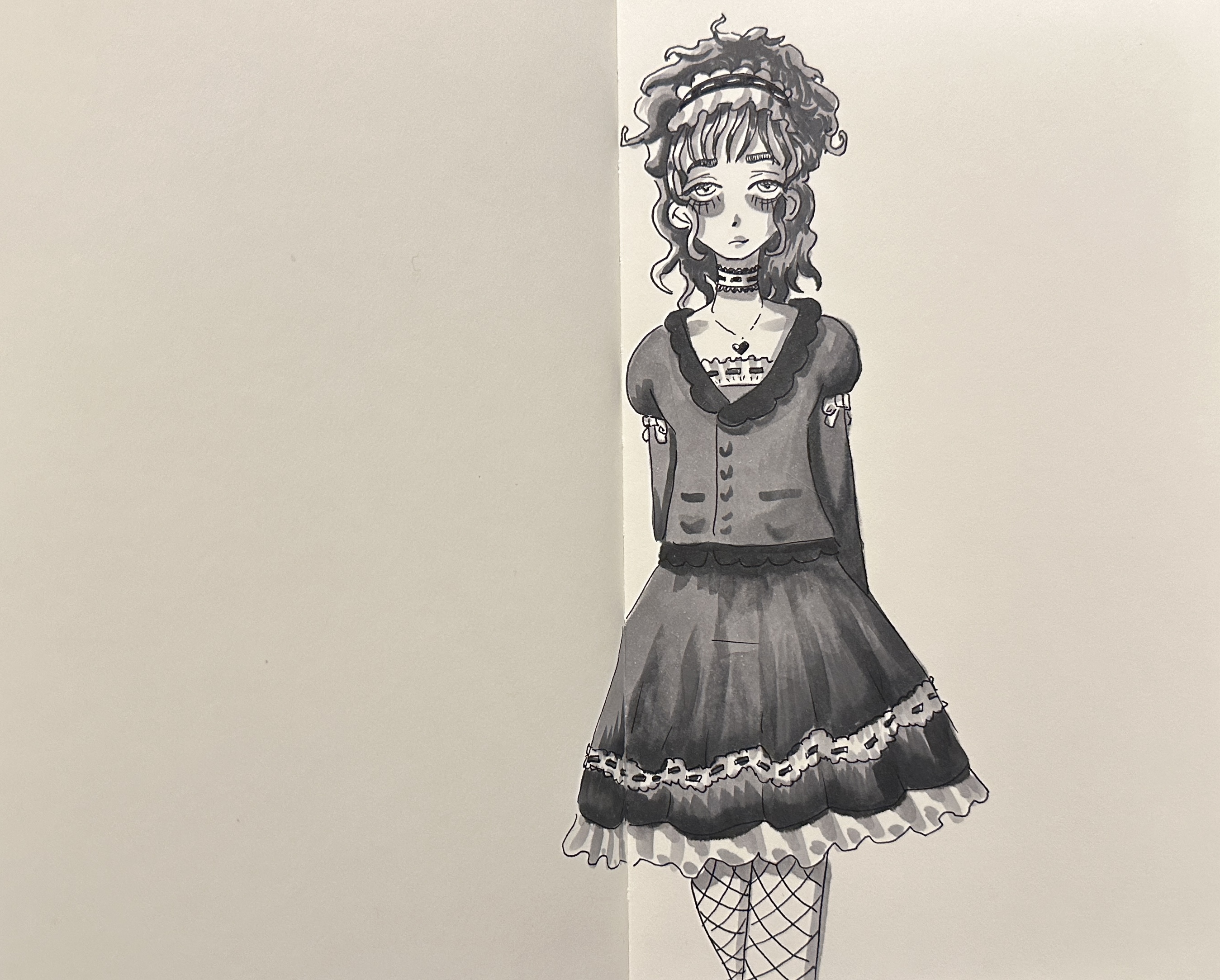 A woman dressed in a thick grey cardigan over a summer dress and fishnets.